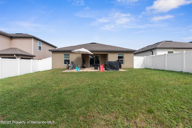 rear view of house with a yard and a patio area