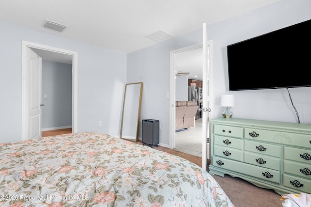 bedroom with light carpet and stainless steel fridge