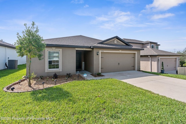 view of front of house featuring a garage, cooling unit, and a front lawn