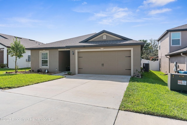 ranch-style house with a garage, central AC unit, and a front lawn