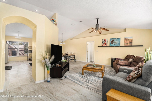 living room with ceiling fan with notable chandelier, vaulted ceiling, and a textured ceiling