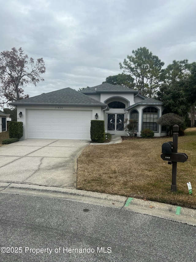 view of front of property featuring a garage and a front lawn