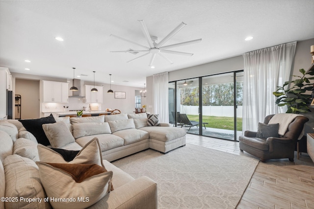 living room with a chandelier, a textured ceiling, and light hardwood / wood-style floors