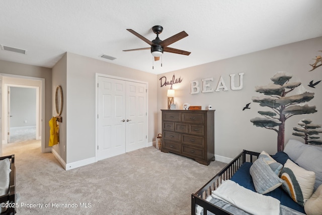 bedroom featuring light carpet, ceiling fan, and a closet