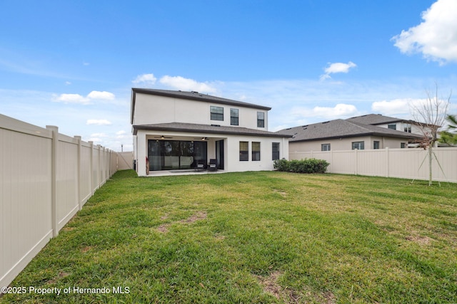 back of property featuring ceiling fan and a lawn