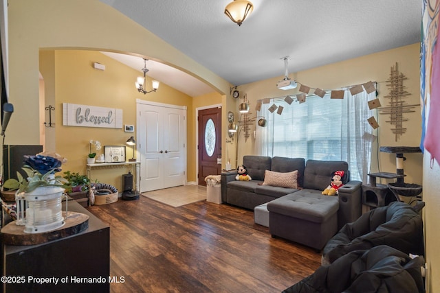 living room featuring vaulted ceiling, dark wood-type flooring, and a textured ceiling