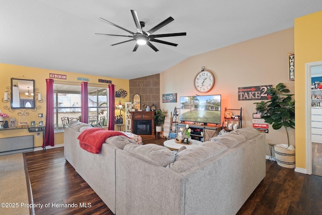 living room with lofted ceiling, a large fireplace, dark hardwood / wood-style floors, and ceiling fan