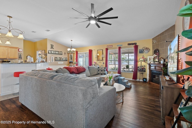 living room with lofted ceiling, ceiling fan with notable chandelier, and dark hardwood / wood-style flooring