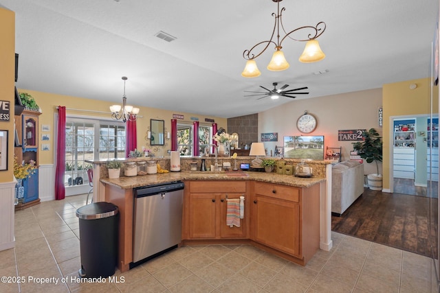 kitchen featuring dishwasher, sink, hanging light fixtures, a kitchen island with sink, and light stone counters