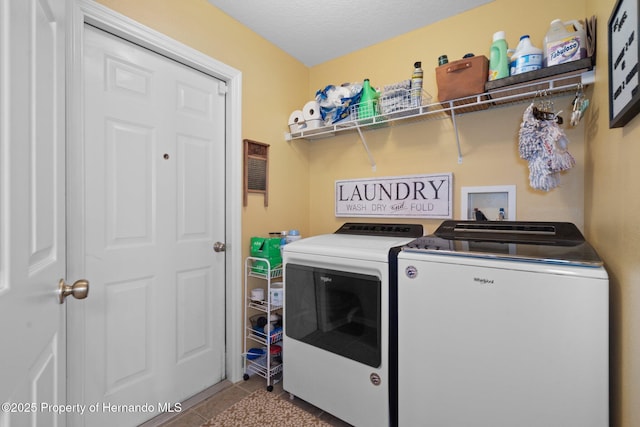 clothes washing area with independent washer and dryer and light tile patterned floors