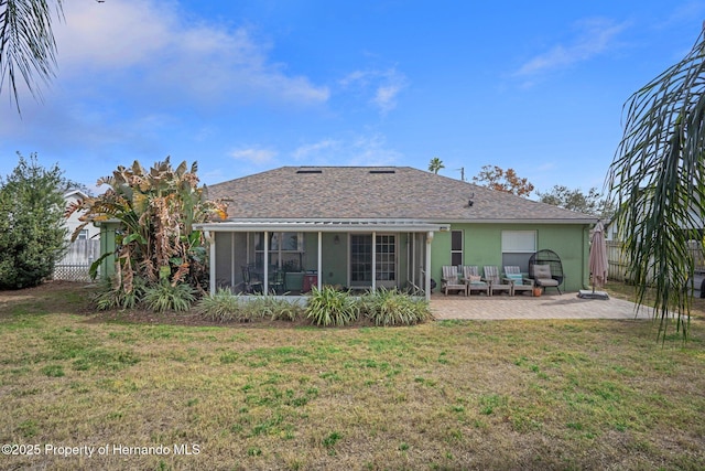 rear view of house featuring a sunroom, a patio area, and a lawn