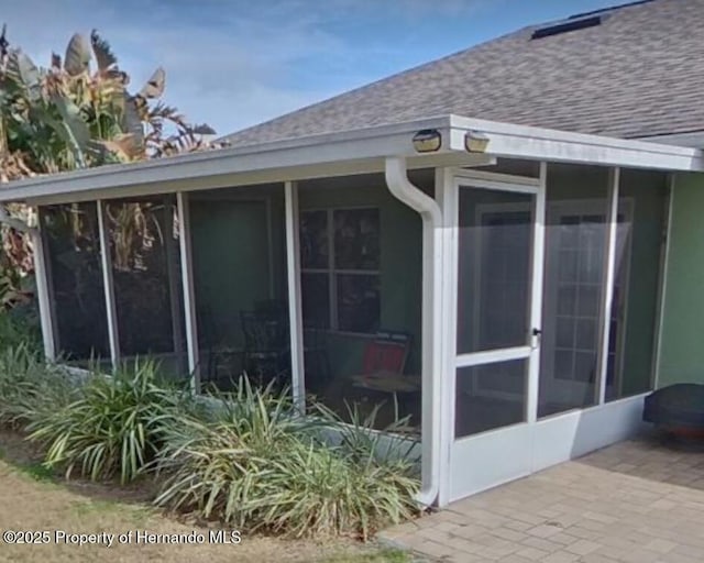 view of property exterior with a sunroom