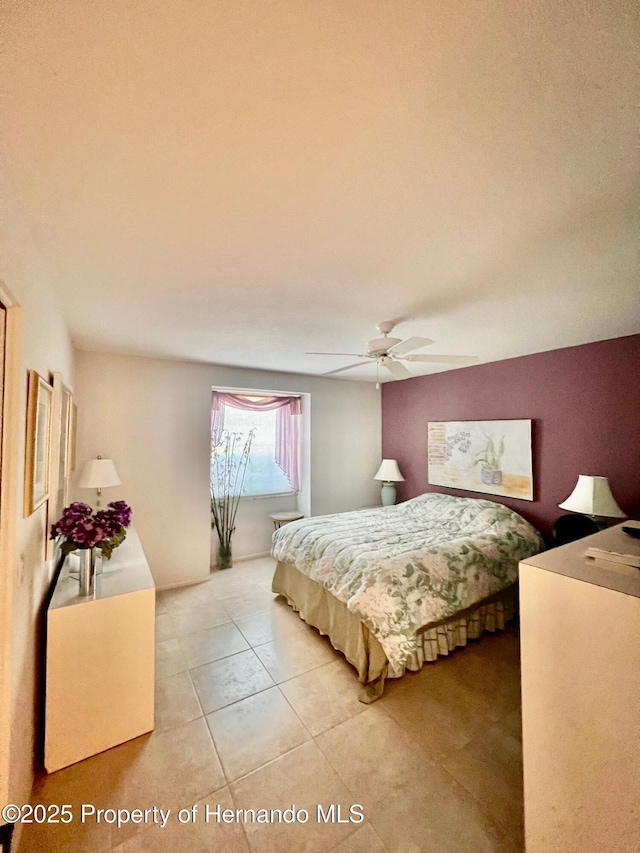 tiled bedroom featuring ceiling fan