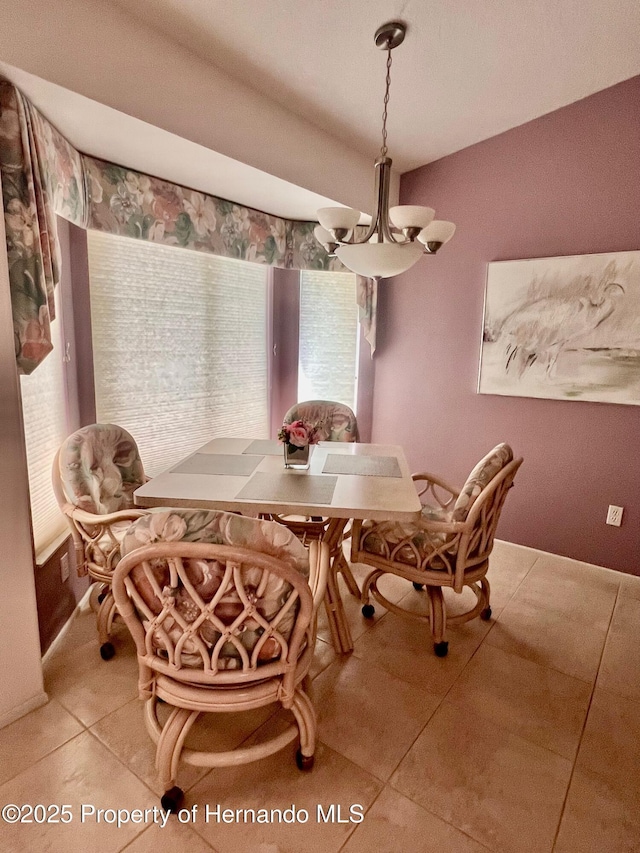 dining space with an inviting chandelier and light tile patterned floors