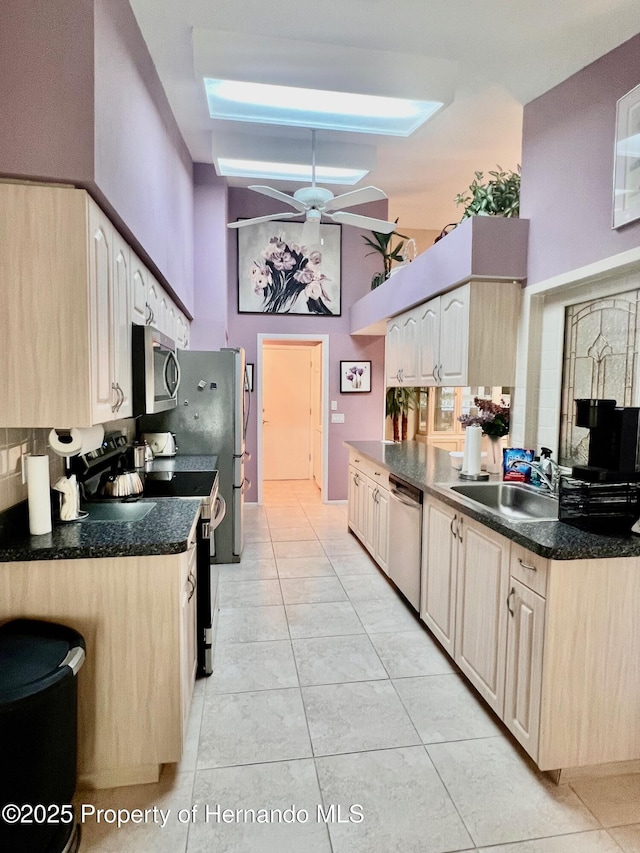 kitchen with sink, light brown cabinets, kitchen peninsula, ceiling fan, and stainless steel appliances