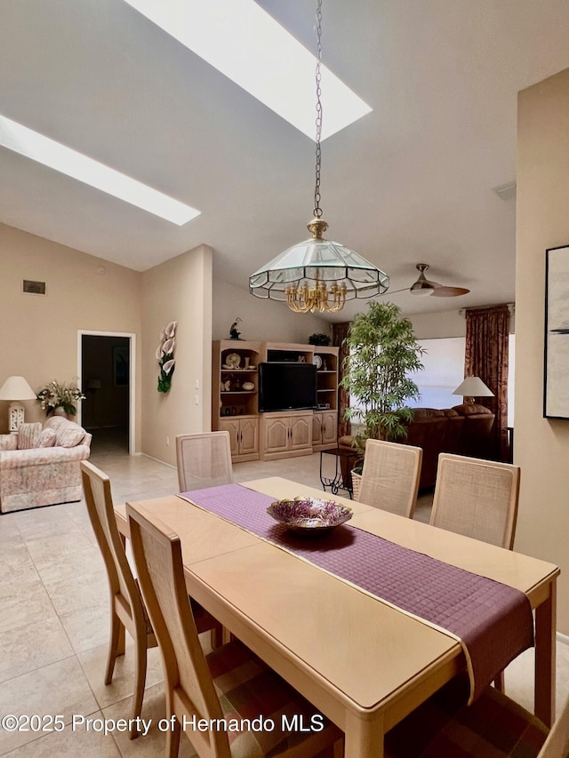 tiled dining space with ceiling fan and lofted ceiling