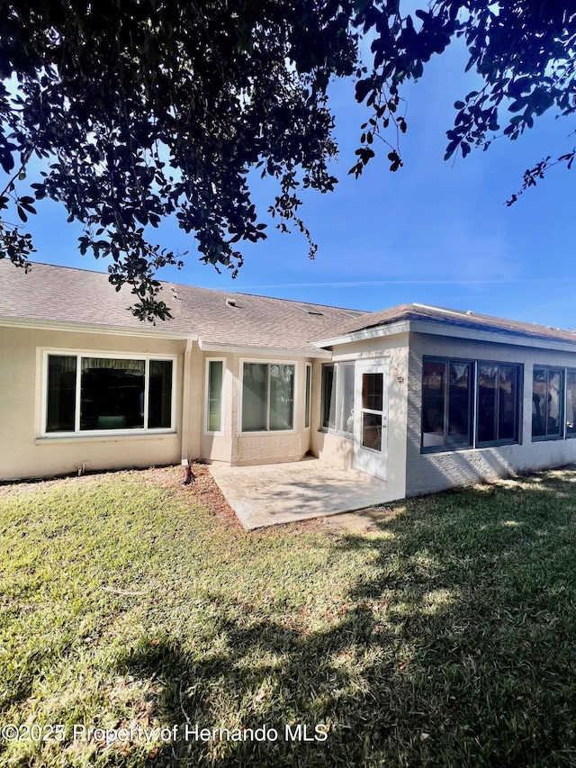 rear view of house featuring a yard and a patio