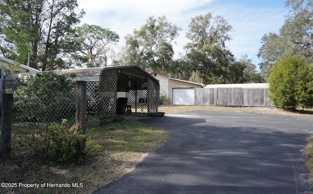 view of front of home with a garage, an outdoor structure, and a carport