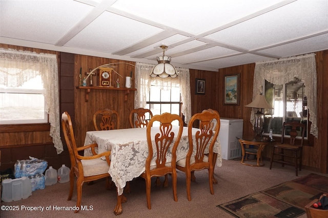 dining space featuring carpet flooring and wooden walls