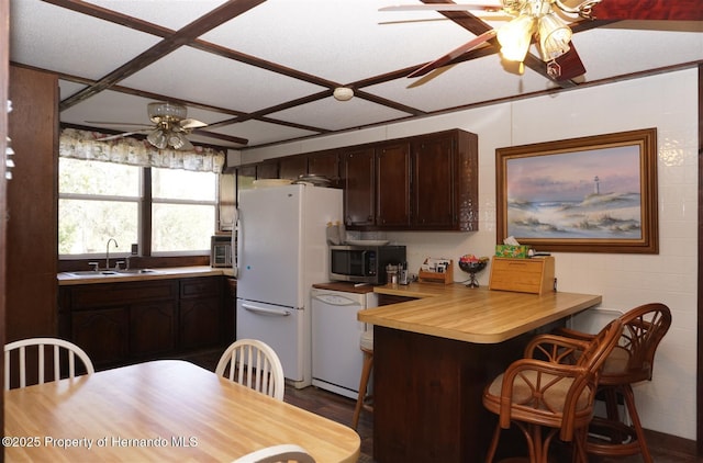 kitchen featuring wood counters, sink, white appliances, dark brown cabinets, and ceiling fan