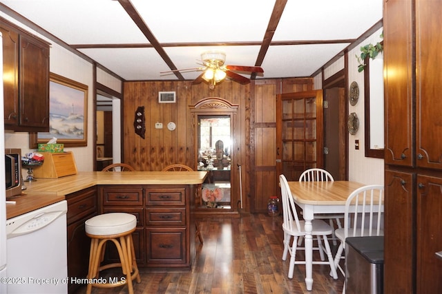 kitchen with butcher block countertops, ceiling fan, wooden walls, dark hardwood / wood-style floors, and white dishwasher