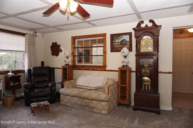 sitting room featuring ceiling fan, coffered ceiling, and carpet