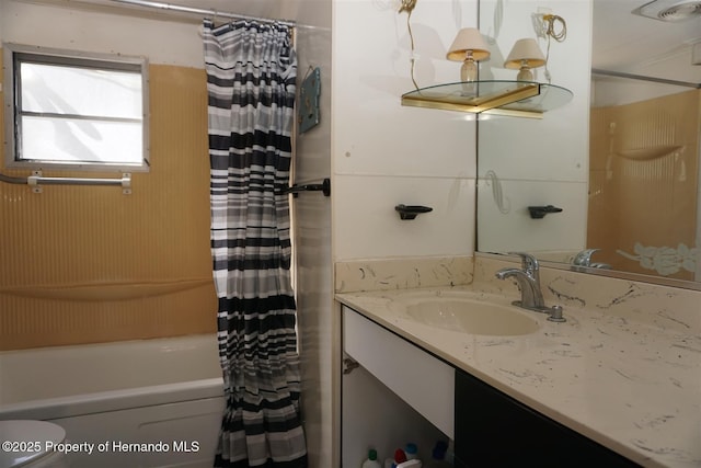 full bathroom featuring vanity, shower / bathtub combination with curtain, and toilet