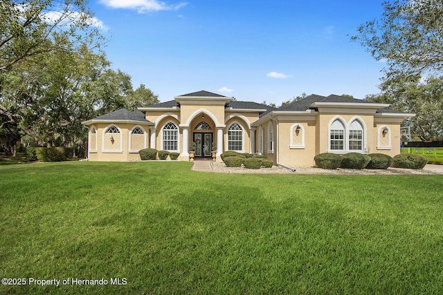 mediterranean / spanish home featuring french doors and a front lawn