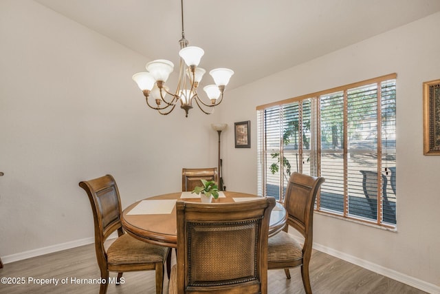 dining room featuring wood-type flooring and a chandelier