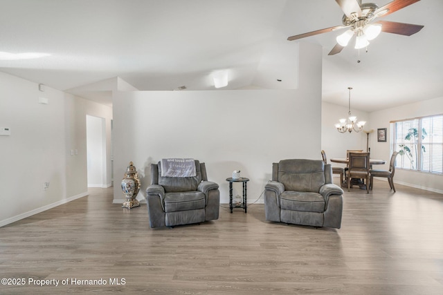 living room with ceiling fan with notable chandelier, lofted ceiling, and hardwood / wood-style floors