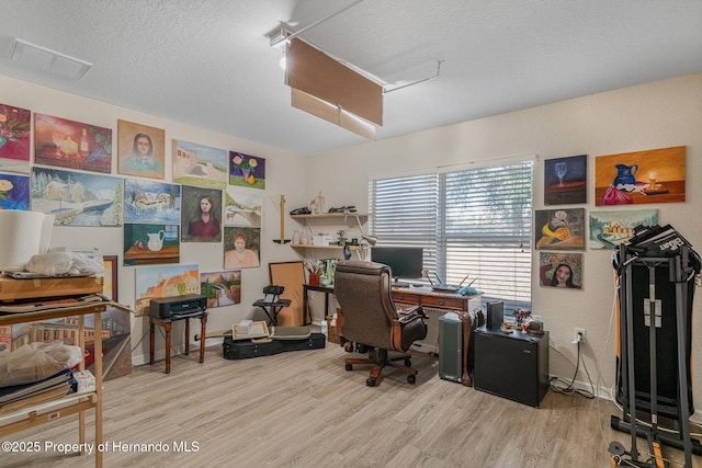 office area with wood-type flooring and a textured ceiling