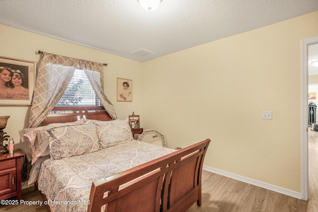 bedroom featuring a textured ceiling and light wood-type flooring