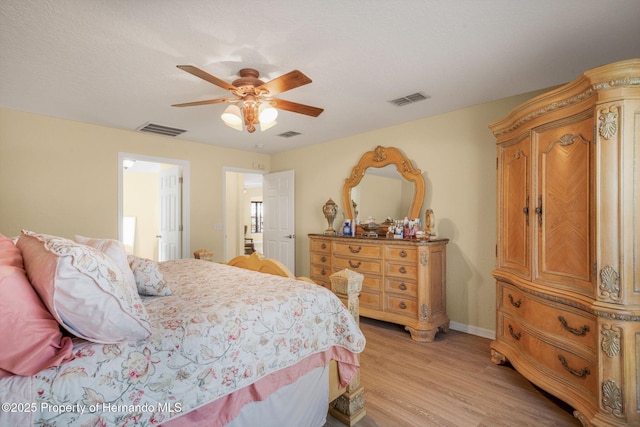 bedroom featuring ceiling fan, light hardwood / wood-style flooring, and a textured ceiling