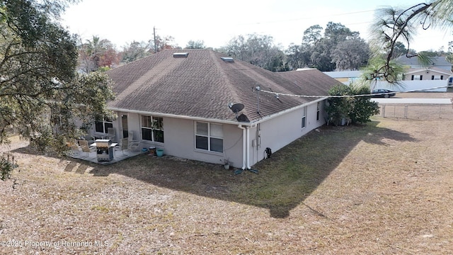 rear view of house with a patio and a lawn