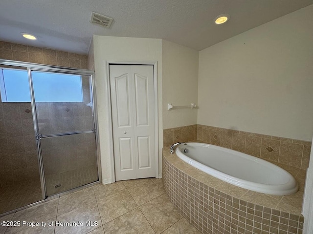 bathroom with shower with separate bathtub, tile patterned flooring, and a textured ceiling