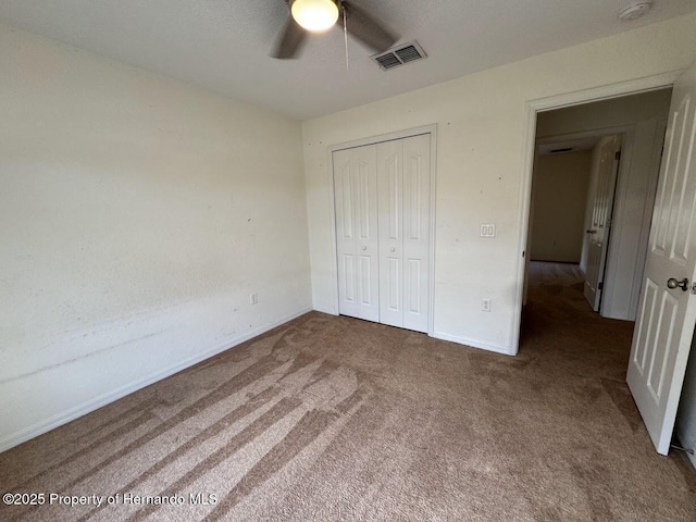 unfurnished bedroom featuring ceiling fan, dark carpet, and a closet