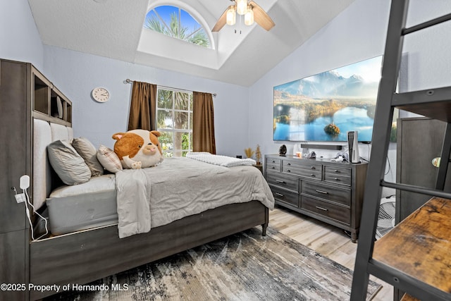 bedroom featuring light wood-style flooring, ceiling fan, and lofted ceiling