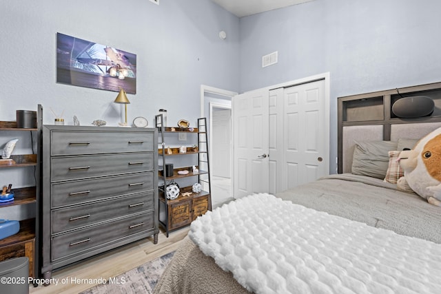 bedroom with visible vents, a closet, and light wood-style flooring