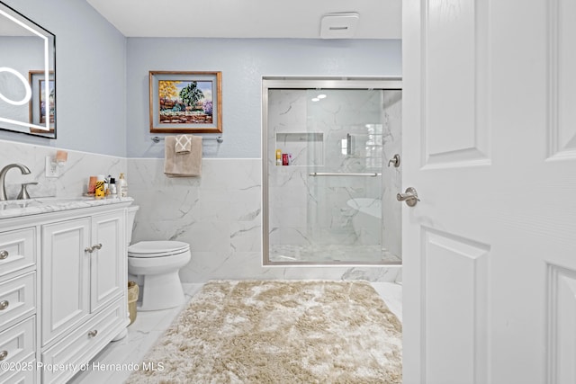 bathroom featuring tile walls, vanity, toilet, a marble finish shower, and marble finish floor