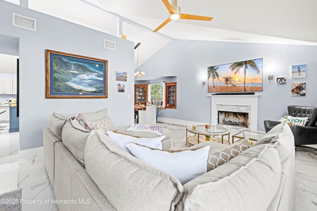 living room with a high end fireplace, vaulted ceiling, visible vents, and marble finish floor