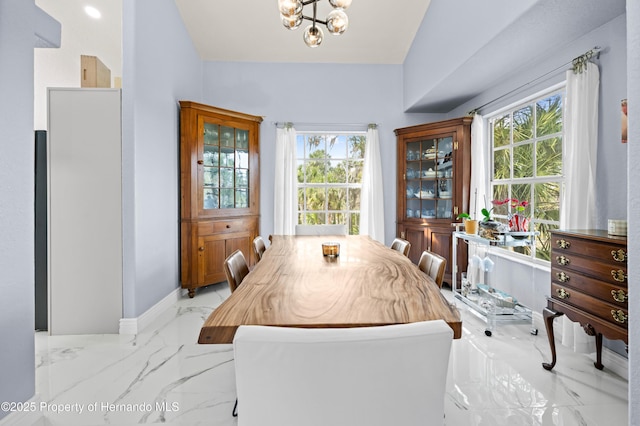 dining room with a chandelier, baseboards, a healthy amount of sunlight, and marble finish floor
