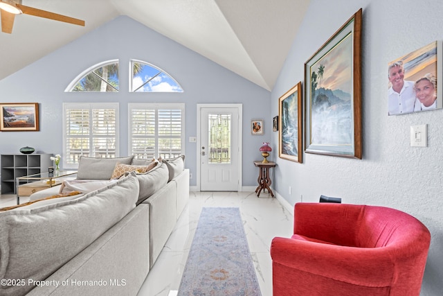 living room with lofted ceiling, a ceiling fan, and marble finish floor