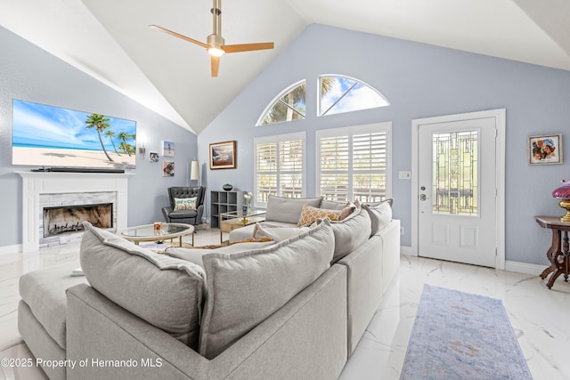 living area featuring marble finish floor, a high end fireplace, baseboards, a ceiling fan, and lofted ceiling