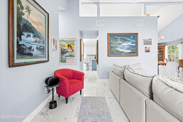 living area with baseboards, visible vents, a high ceiling, and marble finish floor