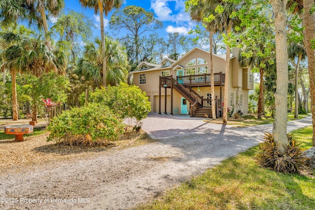 view of front of property with driveway, stairway, a wooden deck, and a garage