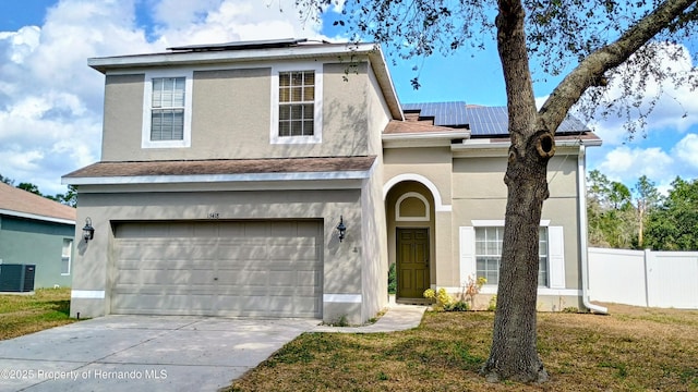 view of property with a garage, central AC unit, a front yard, and solar panels