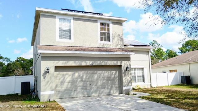 front of property with a garage, cooling unit, a front yard, and solar panels