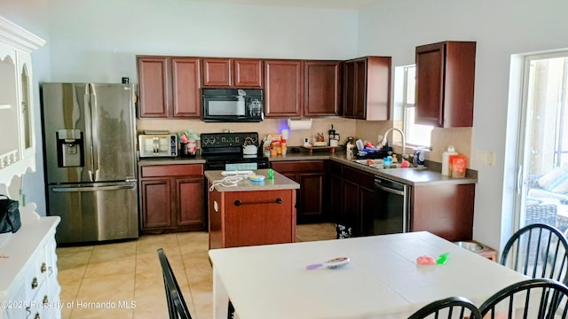 kitchen featuring a kitchen island, sink, light tile patterned floors, and black appliances