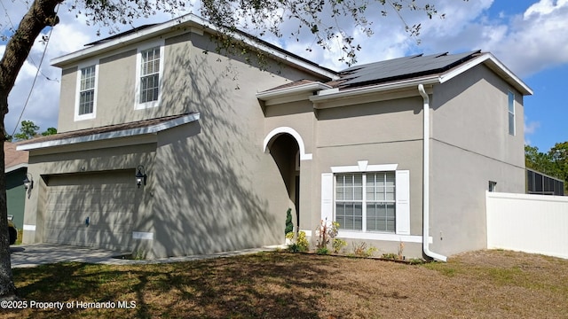 view of home's exterior with a garage, a yard, and solar panels