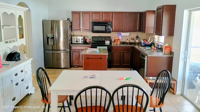 kitchen featuring a kitchen island, sink, decorative backsplash, light tile patterned floors, and black appliances